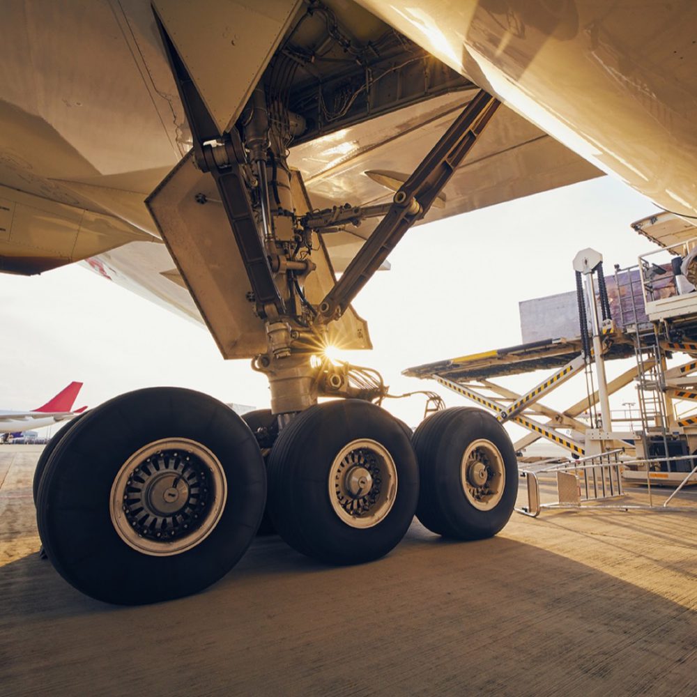 Preparation before flight. Loading of cargo containers to airplane at airport.