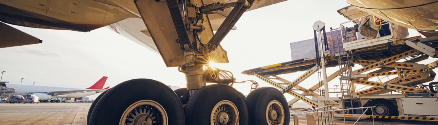 Preparation before flight. Loading of cargo containers to airplane at airport.