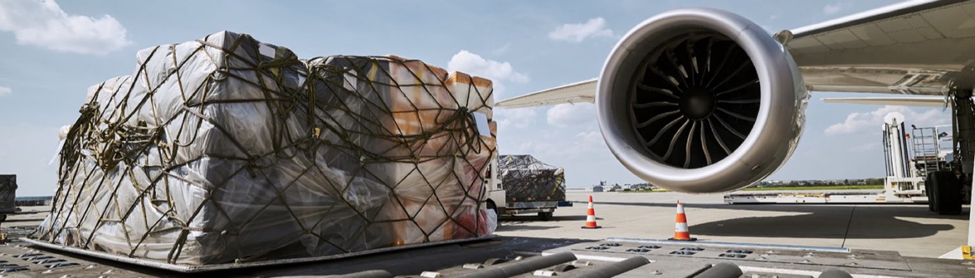 Preparation fright airplane before flight. Loading of cargo containers against jet engine of plane.