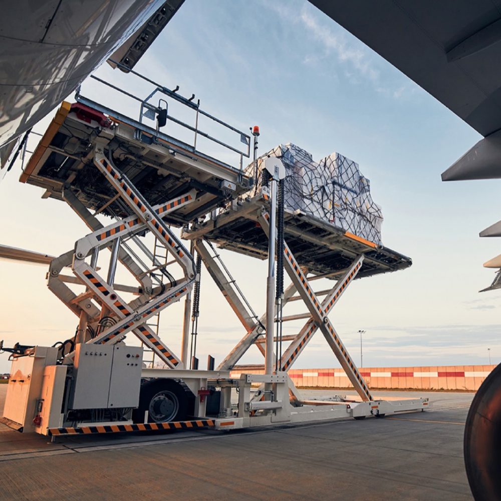 Preparation before flight. Loading of cargo containers to airplane at airport.